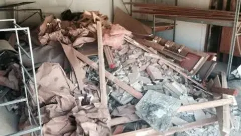 Demolition debris; lumber and dust sheets filling a garage