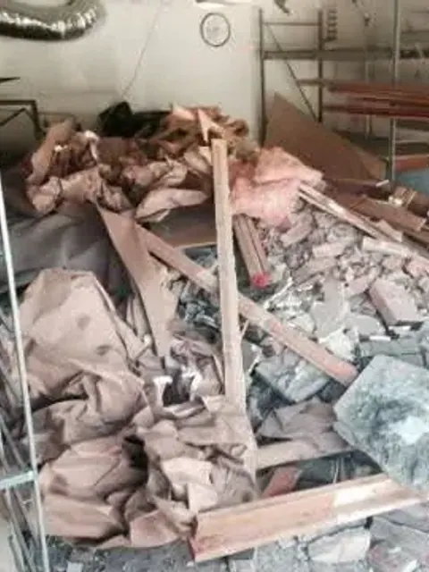 Demolition debris; lumber and dust sheets filling a garage