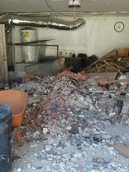 A garage floor buried in broken brick and concrete demolition debris