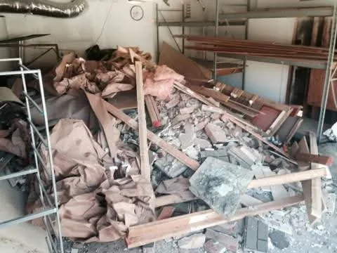 Demolition debris, lumber and dust sheets filling a garage