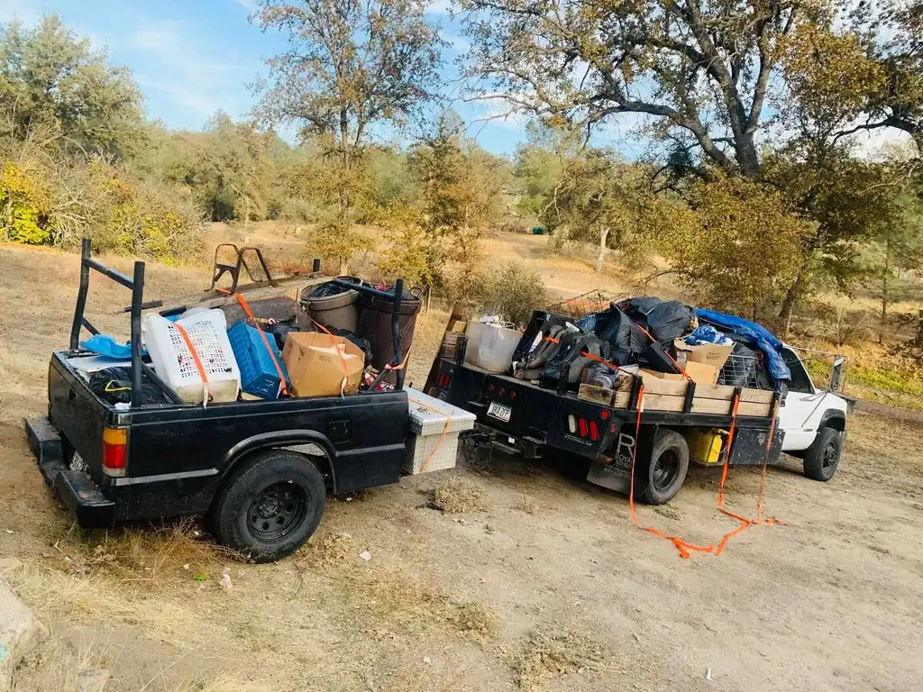 A back patio stacked with boxes, bags and household items before a cleanout
