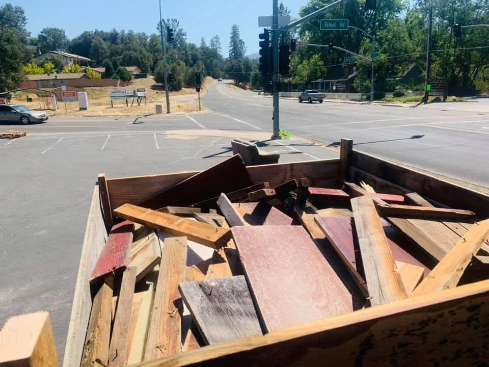 A truck bed loaded with old painted boards and reclaimed lumber