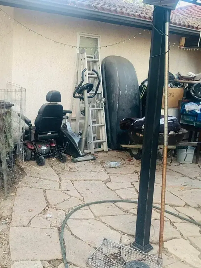 A side yard filled with wire cages; a punching bag and cut branches