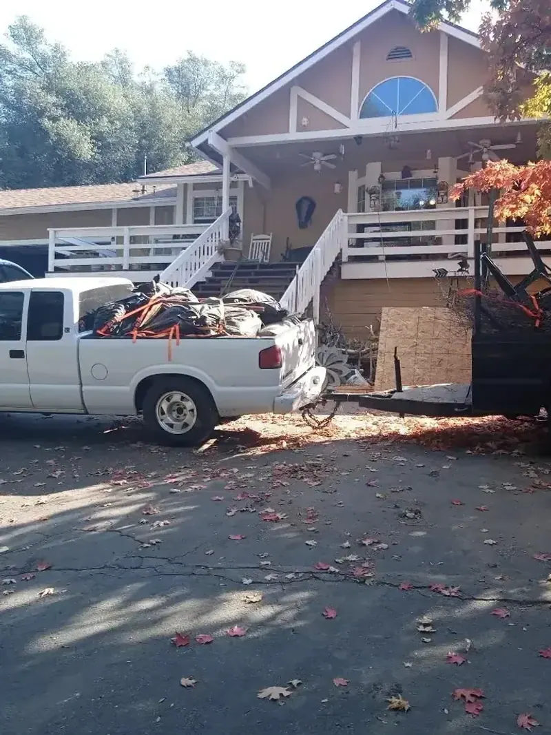 A truck and trailer loaded with patio furniture and yard debris
