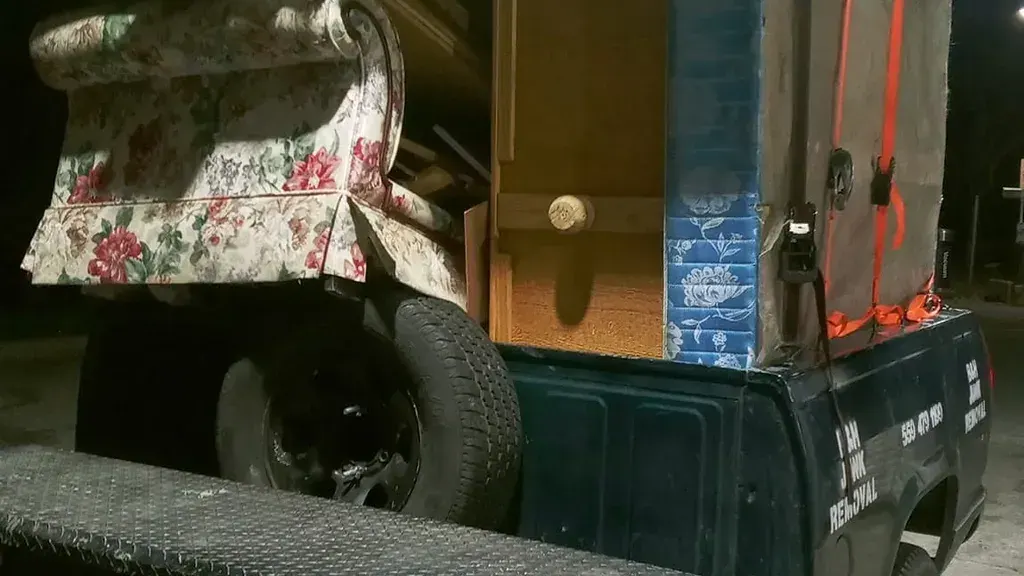 A truck loaded with mattresses; a dresser and an armchair at the end of a day