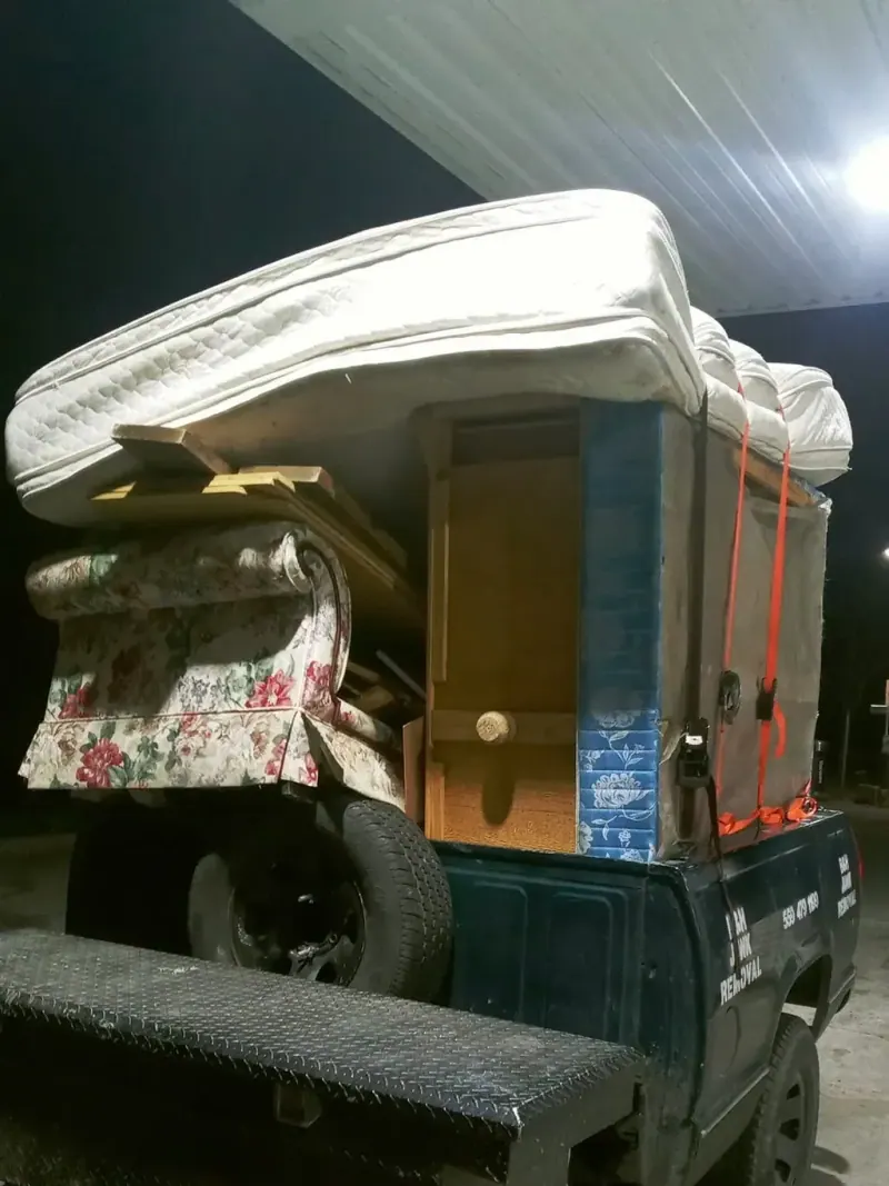 A truck loaded with mattresses; a dresser and an armchair at the end of a day