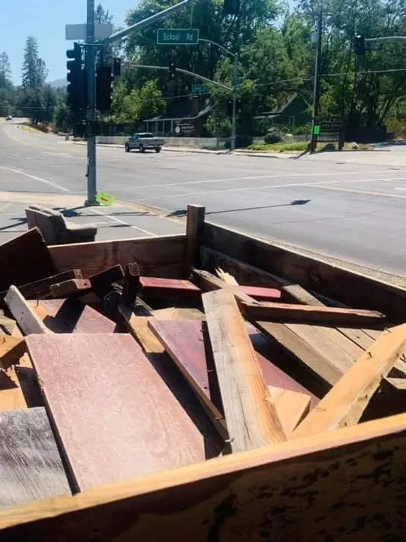 A truck bed loaded with old painted boards and reclaimed lumber