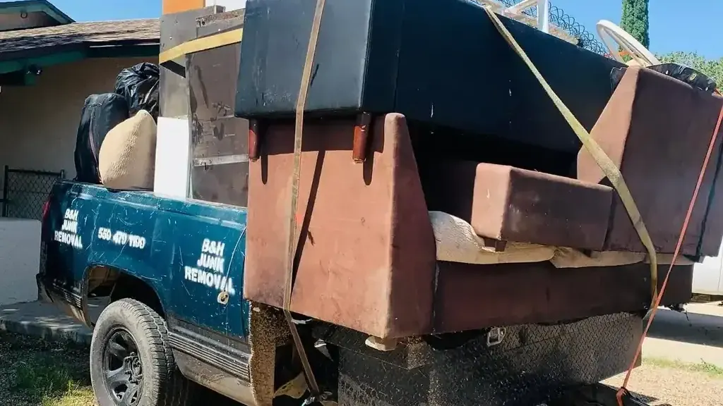 Sofas; cabinets and a mattress strapped onto the B&H Junk Removal truck