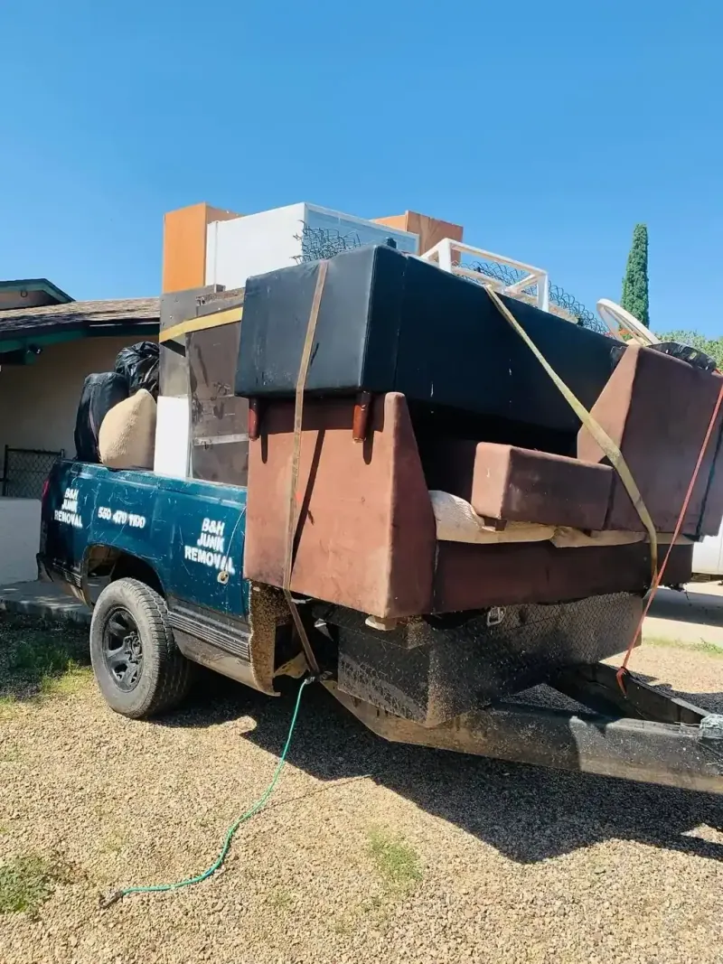 Sofas; cabinets and a mattress strapped onto the B&H Junk Removal truck
