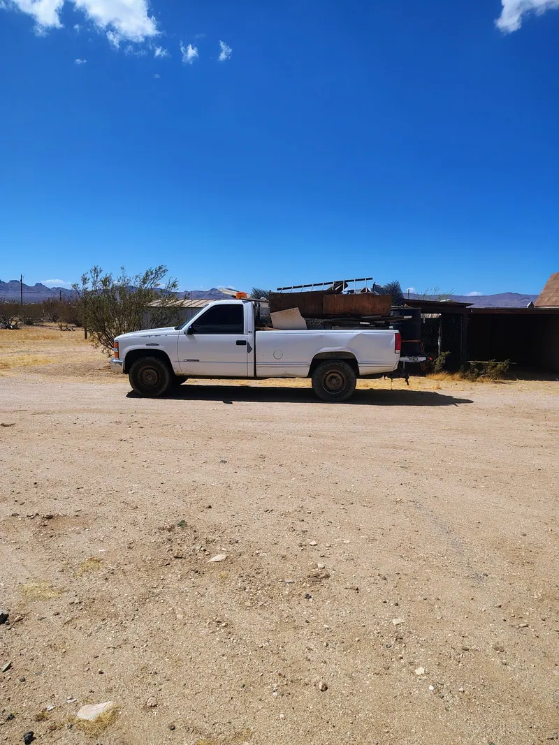 The pickup loaded with timber; sheet metal and torn-out building debris